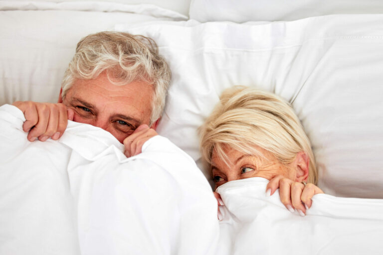 elderly-couple-lying-in-bed-smiling